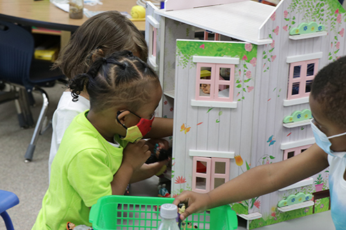 Children play with a dollhouse